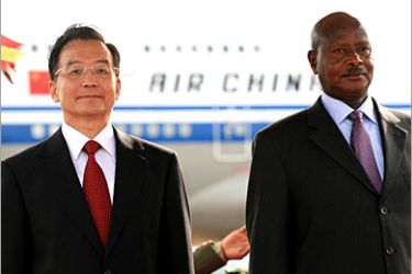 REUTERS /China's Premier Wen Jiabao (L) and Uganda's President Yoweri Museveni watch the honour guard on Wen's arrival at Entebbe international airport, 47 km (29 miles) southwest of Uganda's capital Kampala, June 23, 2006. Wen is on a one-