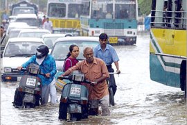 AFP / Indian commuters make their way through a water-logged street after a heavy downpour flooded parts of the Indian capital, in New Delhi 27 June 2006. The sudden rainstorm brought temporary respite from rising temperatures in the