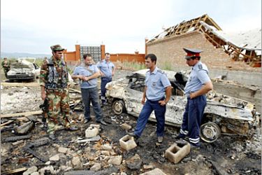 AFP - Policemen inspect a blast site of a car at outskirts of the village of Yekazhevo in Ingushetia, 10 July 2006. Shamil Basayev, the Chechen rebel leader who took responsibility