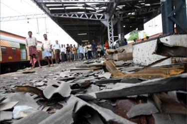 Commuters wait for a local train next to the blast site at Mahim railway station in Mumbai 12 July 2006. The death toll from a wave of coordinated blasts on commuter trains in India's financial capital Mumbai has risen to 174 with 485 people injured, police said 12 July.