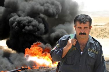 afp/A member of the Oil Protection Police leaves the site of a burning oil pipeline near the northern city of Kirkuk, 03 July 2006