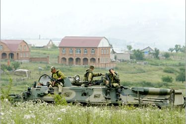 AFP - Russian special Interior troops forces soldiers sit on the APC near a blast site of a car at outskirts of the village of Yekazhevo in Ingushetia, 10 July 2006. Shamil Basayev, the