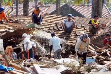 People search for their belongings from the remains of their destroyed house in Pangandaran 19 July 2006. Rescue workers dug with bare hands in a grim search for more bodies after nearly 400 people were confirmed killed in the second tsunami to strike Indonesia in as many years.