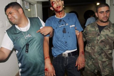 A wounded Palestinian is carried to hospital after an Israeli air strike on a house in Gaza July 24, 2006. Israeli aircraft targeted a warehouse in Gaza on Sunday that the army