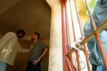 American journalist Paul Salopek (C) speaks with an unidentified person inside a court in El Fasher, nothern Darfur August 26, 2006. Paul Salopek, a photographer
