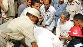 AFP - Egyptian rescue workers carry a victim of a train crash in Qaliub, about 20 km (12 miles) north of Cairo, 21 August 2006. At least 43 people were killed today when two trains
