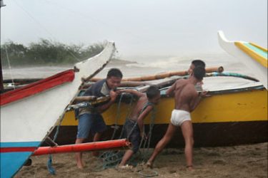 f_Fisherman pull their boats to safety from big waves battering Bulan in Sorsogon province located in the southern tip of the main Philippine island of Luzon 27 September