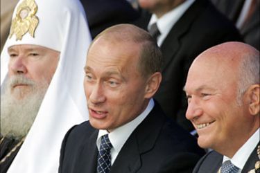 f_Russian President Vladimir Putin (C) speaks with Moscow's Mayor Yuri Luzhkov (R) as Russian Orthodox Patriarch Alexi II sits next to them during the Day of the City celebration in Moscow, 02 September 2006
