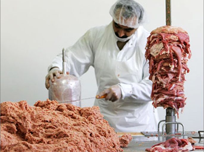 A worker piles meat on a stick in a Kebab production hall in Berlin September 5, 2006. A Kebab producer opened his doors to the media on Tuesday to show his production place