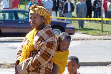 REUTERS/ Somalian immigrants gather outside an apartment were the bodies of four young children were found at the Iroquois Housing projects in Louisville, Kentucky October 6, 2006.