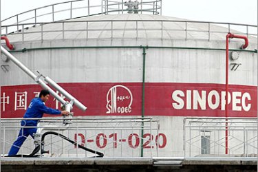 REUTERS/ A labourer works inside an oil storage plant in Changzhi, in northern China's Shanxi province, October 17, 2006. China's monthly oil imports hit a record high in September, with a