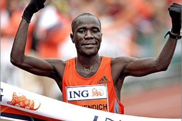 epa00840762 Kenyan debutant Solomon Bushendich crosses the finishing line to win the 31st Amsterdam Marathon on Sunday