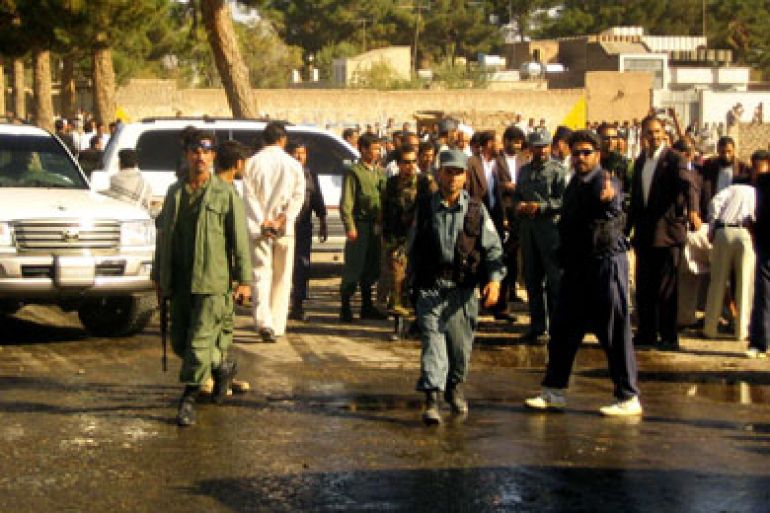 Afghan policemen and locals stand at the site of a remote controlled bomb blast in the western city of Herat, 15 October 2006. A remote-controlled bomb exploded near