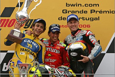 AFP/Tony Elias of Spain (C) celebrates on the podium with Valentino Rossi (L) of Italy and Kenny Roberts(R) of the US after winning the Moto GP race for the Grand Prix of Portugal in Estoril