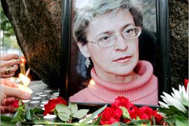 REUTERS/ - People light candles next to a portrait of Russian journalist Anna Politkovskaya during a rally in St. Petersburg October 8, 2006. Russians and Chechens alike on Sunday mourned