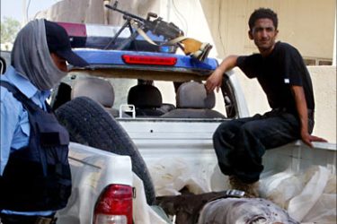 f_The body of an Iraqi lies on the back of police pick-up truck in front of a hospital morgue in the restive city of Baquba northeast of Baghdad 12 October 2006.