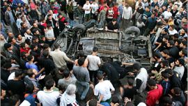 AFP / Palestinians gather around a destroyed vehicle following an Israeli missile attack in Gaza City, 04 November 2006. A member of the armed wing of the radical Islamist movement