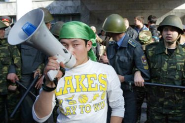 afp/Kyrgyz protestor speaks through a megaphone as soldiers guard the State TV broadcasting center during an opposition rally in central Bishkek, 03 November 2006