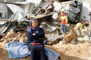 عائلة فلسطينية فوق ركام منزلها الذي دمره الاحتلال في بيت حانون
