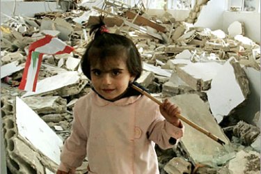AFP / A Lebanese schoolgirl waves her national flag in a heavily damaged school in the southern Lebanese village of Bint Jbeil, 18 November 2006, four days before Lebanon's