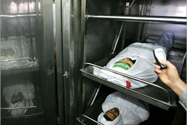 AFP / A Palestinian uses his cellphone to takes photos of two bodies lying in a hospital morgue in Beit Lahia 01 November 2006. Six Palestinians were killed and 35 wounded when the