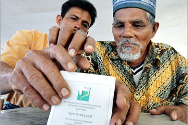 AFP / An elderly man is helped by an election officer to cast his ballot at a polling station in Banda Aceh, 11 December 2006. Polls opened in Indonesia's Aceh province 11 December for