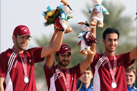 f_Qatar Men's 10m Running Target Mixed Team silver medal winners Mohammed Haq (C), Khaled Al-Kuwari (R) and Mohammed Abu Teama stand on the shooting winners' podium at the 15th Asian Games in Doha, 06 December 2006. Kazakhistan won the gold and Vietnam took the Bronze.