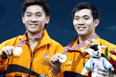 AFP / Malaysian men's doubles team Koo Kien Keat and Tan Boon Heong display their gold medals on the podium following the men's doubles badminton final at the 15th Asian Games in Doha 09 December 2006. Malaysia won gold followed by Indonesia with silver and Indonesia and South Korea with bronze respectively. AFP PHOTO/Laurent FIEVET