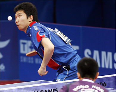 لاعب كوريا الجنوبية يسدد ضربة قوية على خصمة لاعب هونغ كونغ في مباراة نصف النهائي في تنس الطاولة