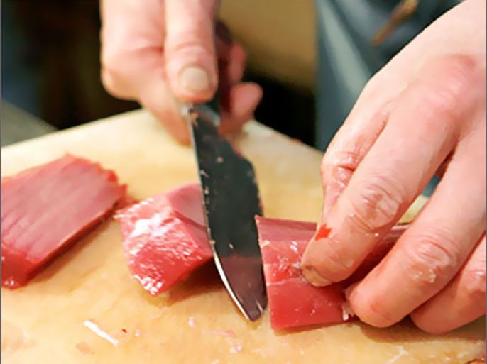 REUTERS/ A wholesaler fillets a tuna at the Tsukiji fish market in Tokyo in this December 12, 2006 file photo. To feed its tuna hunger, Japan ranges far and wide. Tighter international fishing