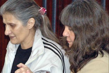 f_Bulgarian nurses Valia Cherveniashlka (R) and Snezhana Dimitrova hold hands as they arrive for a final hearing in the case of infecting hundreds of Libyan children with the AIDS virus at the heavily-protected Libyan High Court in Tripoli 19 December 2006.
