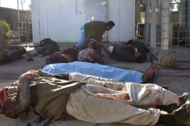 An Iraqi inspects unidentified bodies for victims of violence outside a morgue of a hospital in the restive city of Baquba, northeast of Baghdad, 19 December 2006. Eight bodies were found today across the city one of them is for an Iraqi army soldier.