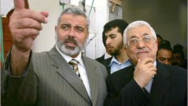 AFP (FILES) Palestinian leader Mahmud Abbas (R) listens to Prime Minister Ismail Haniya (L) as they inspect the PM's destroyed Gaza City office which was struck by Israeli