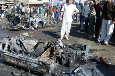Iraqis look at a car bomb in which one person was killed and five wounded in Baghdad 31 December 2006. Saddam Hussein was buried today one day after his hanging