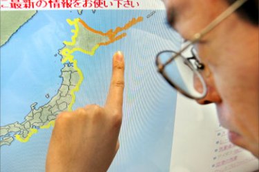 Weather forecaster Tetsuya Maekawa points out where Japan's Meteorogical Agency issued a tsunami warning after a massive 8.3-magnitude quake occured in the northwestern Pacific Ocean at the headquarters of the agency in Tokyo, 13 January 2007. A minor tsunami reached northern Japan easing fears after the was issued following the earthquake.