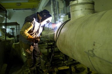 (FILES) A worker welds a pipe inside the turbine building of the Bushehr nuclear power plant, 1,000km south of Tehran, 22 June 2005. Iran has decided to block 38 inspectors from