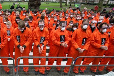 afp - Amnesty International demonstrators, wearing orange prisoners' jumpsuits, protest outside the US Embassy in London