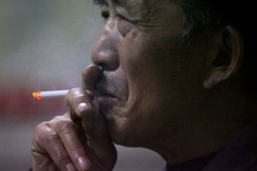An elderly man smokes his cigarette at a stock exchange in Nanjing, east China's Jiangsu province January 4, 2007. China will have the world's highest number of lung cancer patients 1 million a year by 2025 if