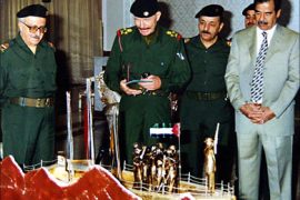 f_released by the offcial Iraqi News Agency (INA) shows Iraqi President Saddam Hussein (R) looking at a gift offered to him by the ruling Baa'th party