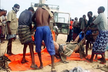 f_Somali men carry a body that was pulled from the wreckage of a Belarussian cargo plane 24 March 2007 that was shot down by insurgents over Mogadishu during a third straight
