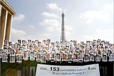 AFP / 153 members of Paris-based media watchdog Reporters Without Borders (RSF) pose with famous French journalists' portraits, to symbolize the 153 journalists killed in Iraq the last