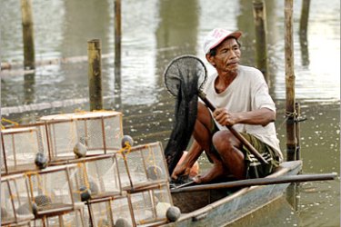 AFP / Romeo Istanislao, 67, carries some of the shrimps he caught in his traps after a day of work in the river that passes through San Isidro, Negros Occidental, Central Philippines,