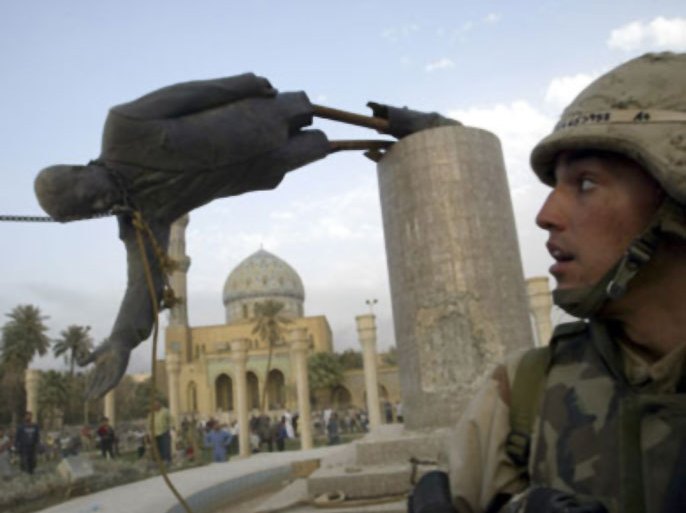 A U.S. soldier watches as a statue of Iraq's President Saddam Hussein falls in central Baghdad in this April 9, 2003 file photo. This photo accompanies the WITNESS-IRAQ