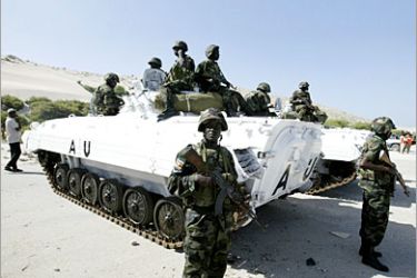 REUTERS/ Ugandan soldiers stand guard next to a U.N. armoured personnel carrier in Mogadishu’s international airport, March 6, 2007. Ugandan soldiers landed in the Somali capital