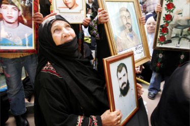 A Palestinian woman holds a picture of her son during a protest calling for the release of Palestinian prisoners from Israeli jails, in Gaza April 9, 2007.