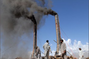 Afghan workers unload bricks from a kiln on the outskirts of Kabul, as the brick-making season begins, 19 April 2007.