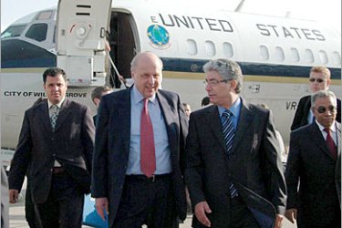 epa00985802 US Deputy Secretary of State John Negroponte (2-L) walks with Libyan Director of the Department of American Affairs at the Ministry of Foreign Affairs Ahmed al-Fitori 2-(R) upon his arrival at Tripoli airport,