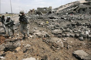 f_US soldiers from Alpha Company, 2nd Battalion, 7th Cavalry Regiment walk nearby a collapsed building following a suicide truck attack, in the northern Iraqi city of Mosul