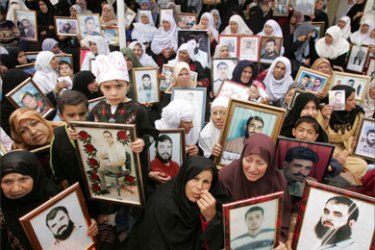 Palestinians hold pictures of their relatives during a protest calling for the release of Palestinian prisoners from Israeli jails, in Gaza April 9, 2007.