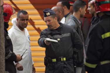 afp - A forensic expert (2ndL) speaks with a member of Moroccan security forces upon his arrival in a restricted area 10 April 2007